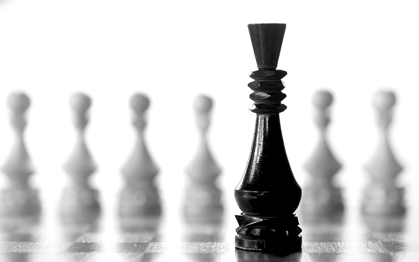A single black chess piece standing sharply in focus with a blurred row of pieces behind it, symbolizing one decisive action creating multiple downstream wins. A single black chess piece standing sharply in focus with a blurred row of pieces behind it, symbolizing one decisive action creating multiple downstream wins.