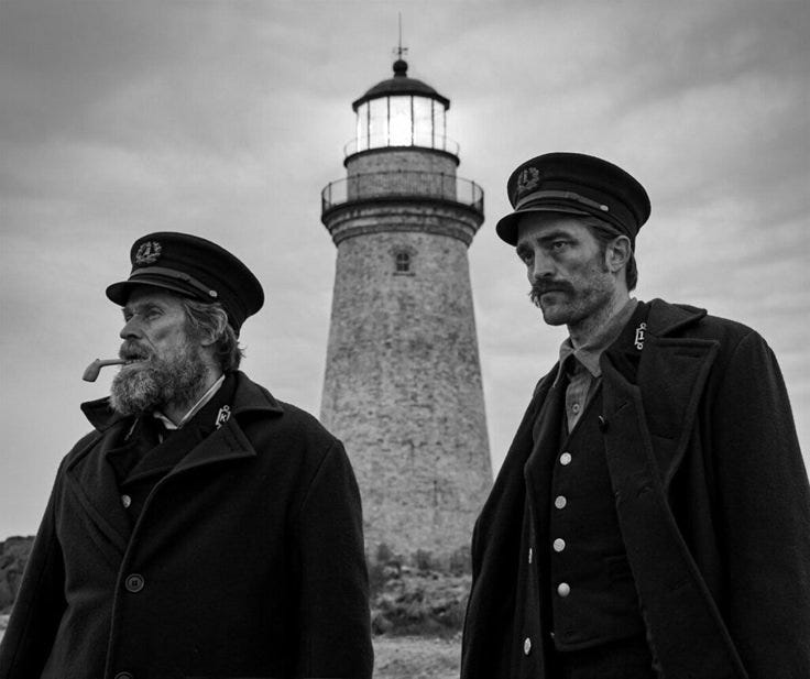 This may contain: two men standing next to each other in front of a lighthouse