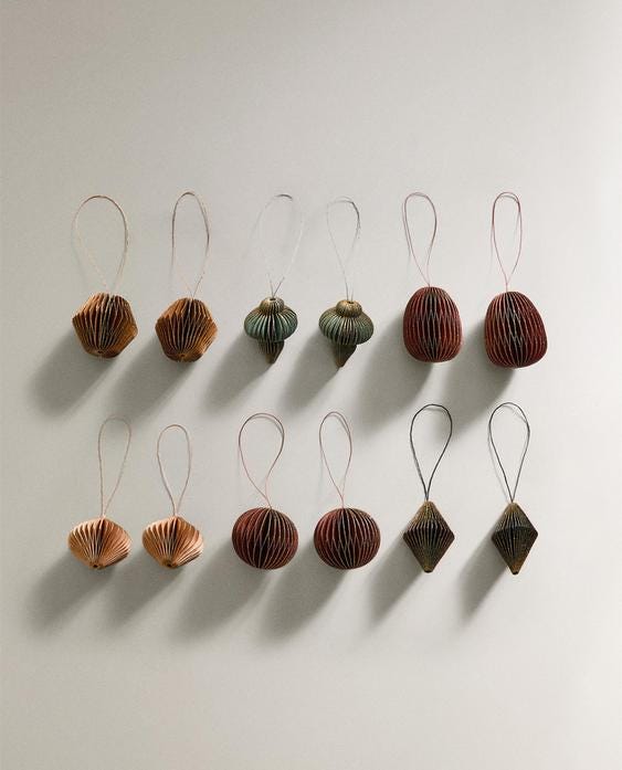 Pack of 12 Christmas ornaments in brown paper with varied shapes, including spheres, diamonds, and fans.