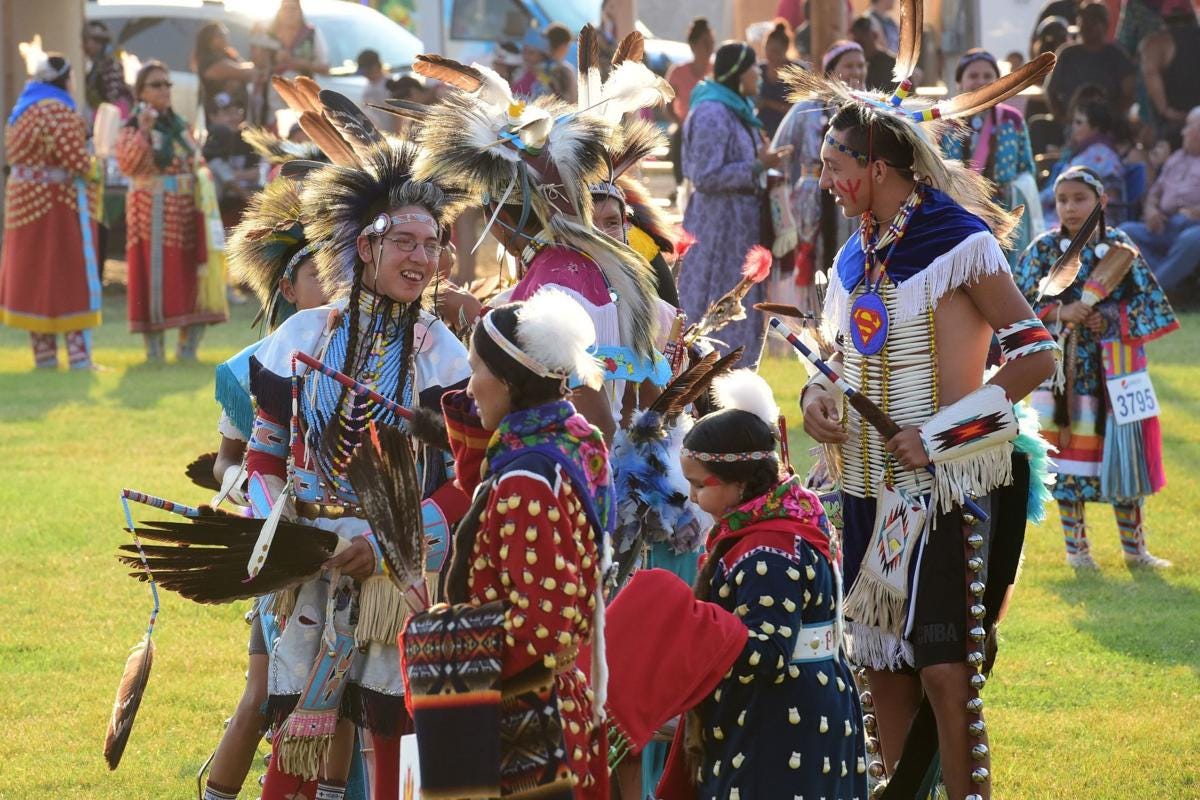 Sun shines on colorful, traditional dress of the Crow people at their annual summer festival.
