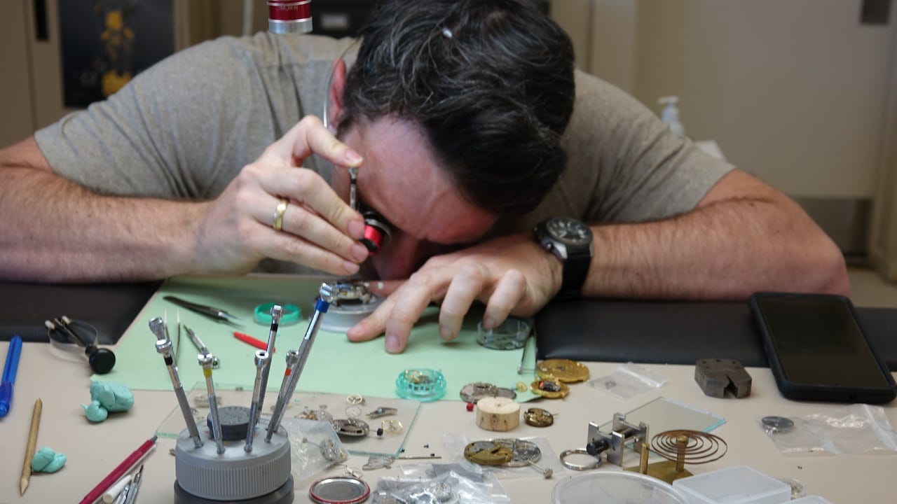 A man looking at tiny pieces of metal.