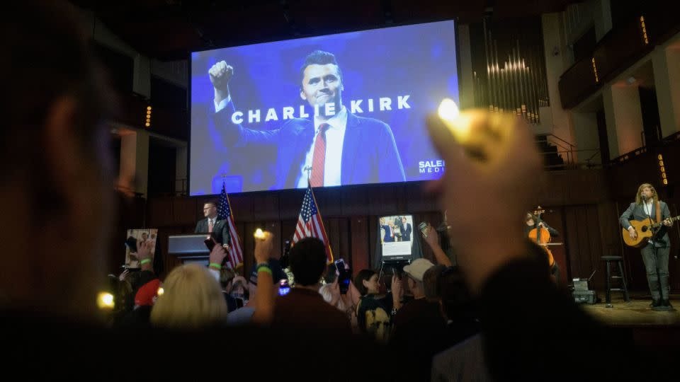 People hold candles and sing during a memorial for Charlie Kirk at the Kennedy Center in Washington, DC, on Sunday. - Rod Lamkey/AP