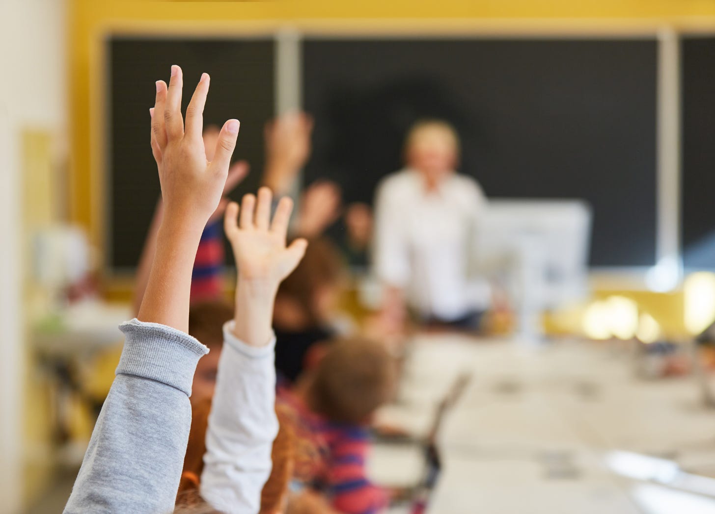 Teacher overwhelmed by multiple responsibilities, symbolizing the challenges of managing both academic duties and sensitive gender identity discussions in schools