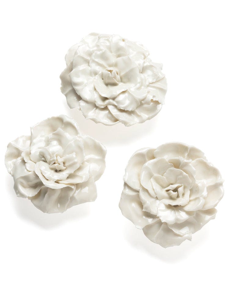 Three delicate, sculpted Porcelain Roses by Rachel Kneebone are arranged in a triangular pattern against a plain white background. Each handcrafted porcelain sculpture has intricately detailed petals, giving them a lifelike appearance, reflecting the artistry associated with the House of Voltaire.