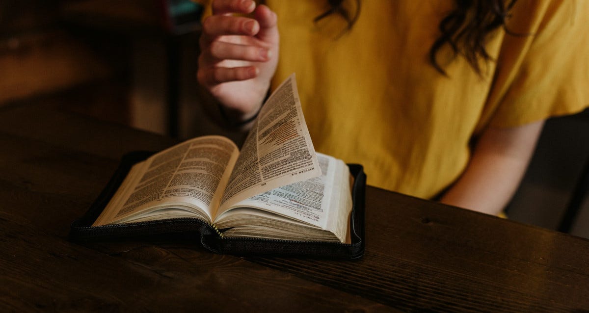 Woman turning the page of a Bible