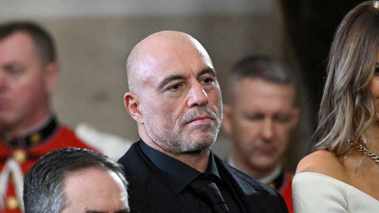 Joe Rogan stands for a benediction after President Donald Trump was sworn in as the 47th US President in the US Capitol Rotunda. - Saul Loeb/Pool/Reuters