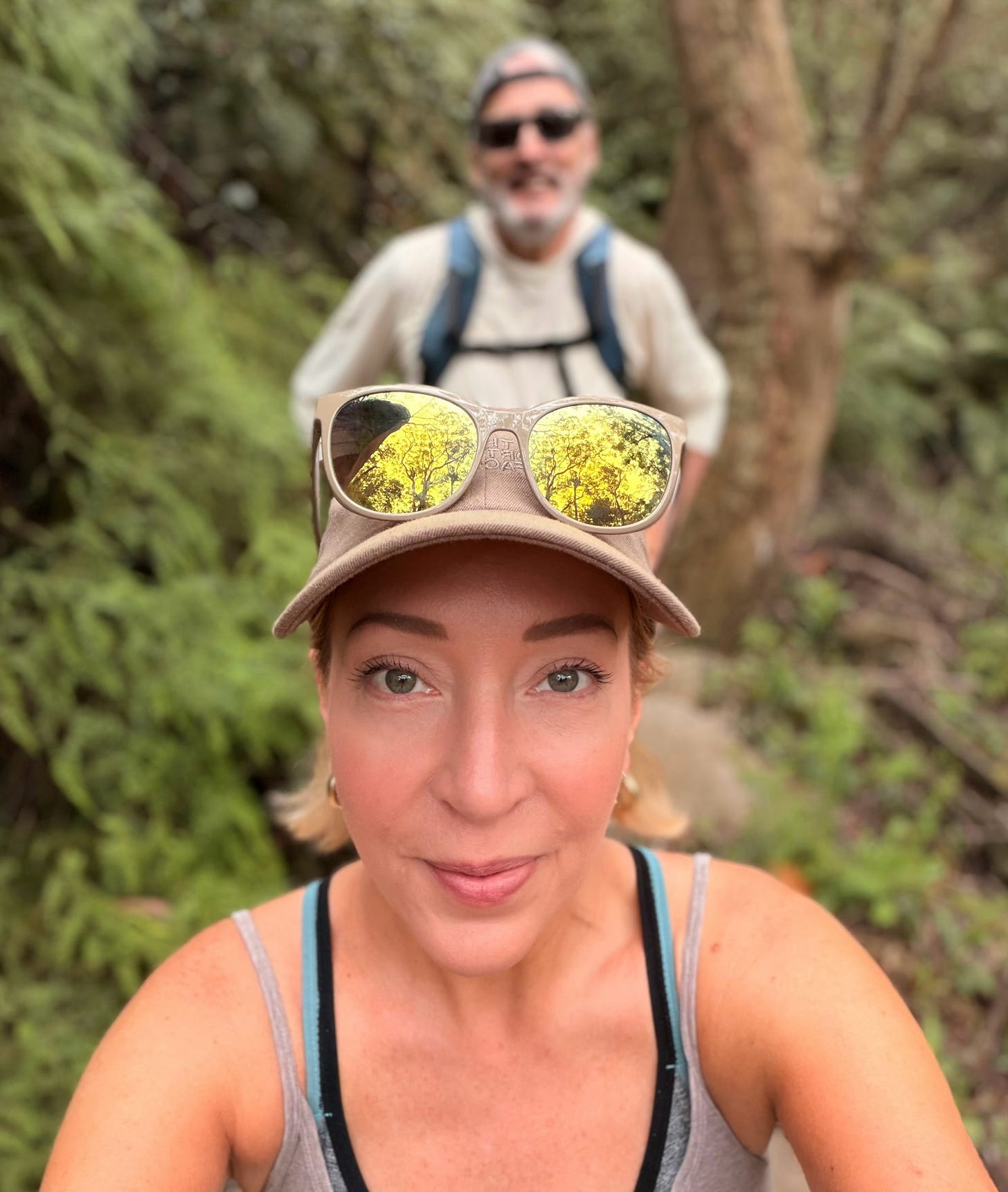 Selfie of Kelly hiking in the Blue Mountains with Nigel behind her on the trail. Selfie of Kelly hiking in the Blue Mountains with Nigel behind her on the trail.