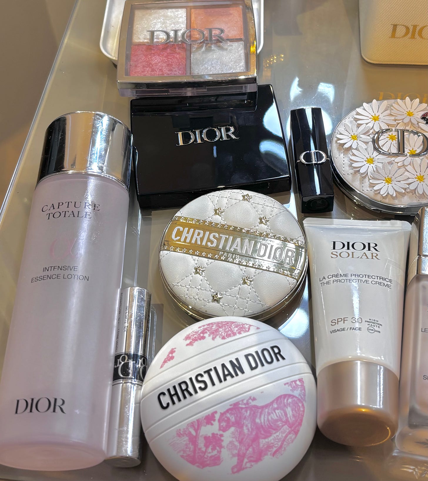 A luxury beauty flat lay of the full Dioriviera Summer 2026 routine tested by The Beauty Ed®, including Dior Capture Totale Intensive Essence Lotion, Dior Solar SPF 30, and the 162 Summer Azur eyeshadow palette.