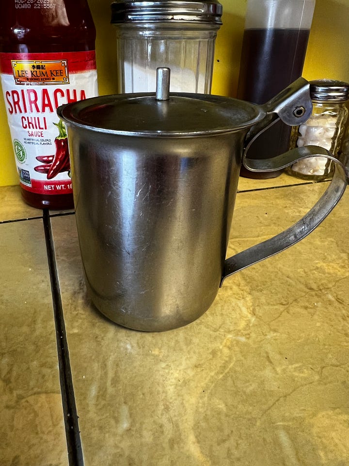 picture of a mug of coffee and a stainless steel milk pitcher on a yellow diner counter