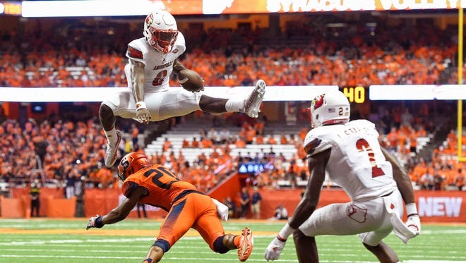 Louisville Cardinals quarterback Lamar Jackson (8) leaps over Syracuse Orange defensive back Cordell Hudson (20) during the second quarter at the Carrier Dome in Syracuse, N.Y. on Sept. 9, 2016. Louisville Cardinals quarterback Lamar Jackson (8) leaps over Syracuse Orange defensive back Cordell Hudson (20) during the second quarter at the Carrier Dome in Syracuse, N.Y. on Sept. 9, 2016.