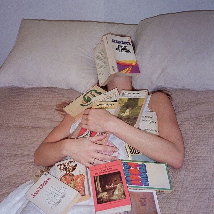 This may contain: a woman laying in bed with lots of books
