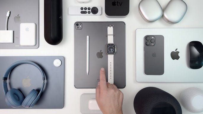Apple Ecosystem: PROS & CONS—a user’s hand hovers over a vast array of Apple products.