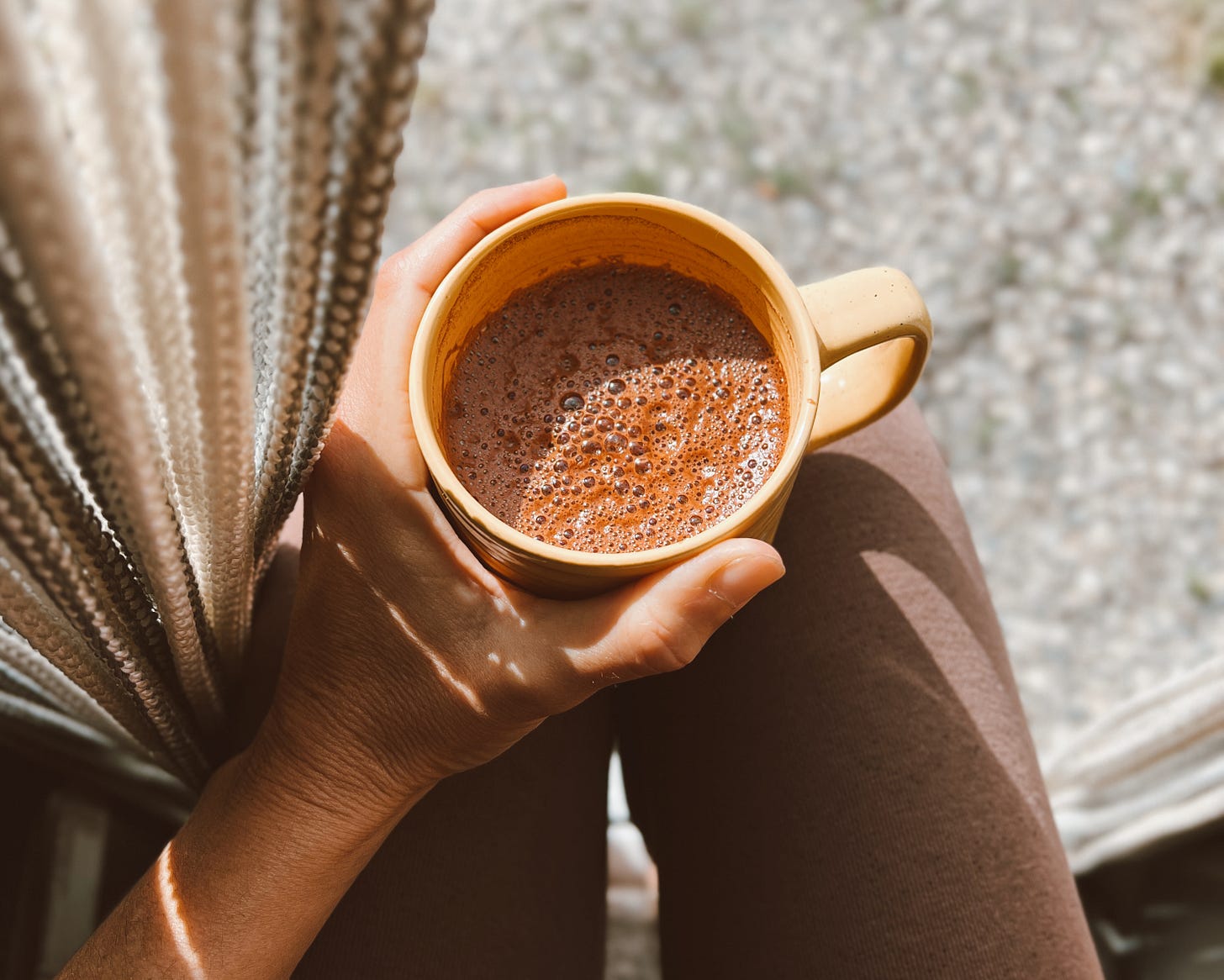 Tasse de cacao sacré tenue sur les genoux