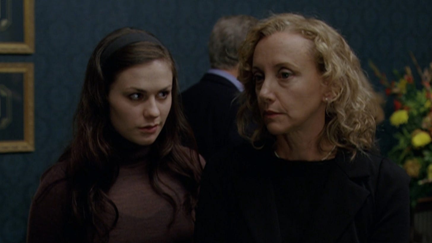 Margaret | Still features Anna Paquin looking directly at J. Smith-Cameron in a funeral setting.