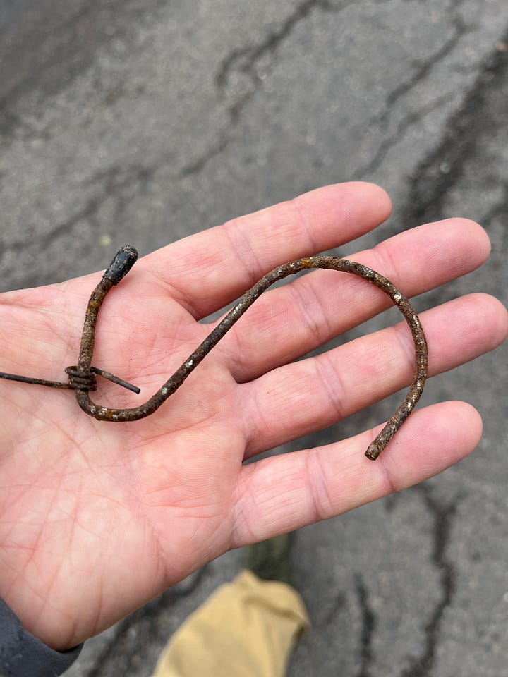Open hands holding metal objects picked up off the ground.