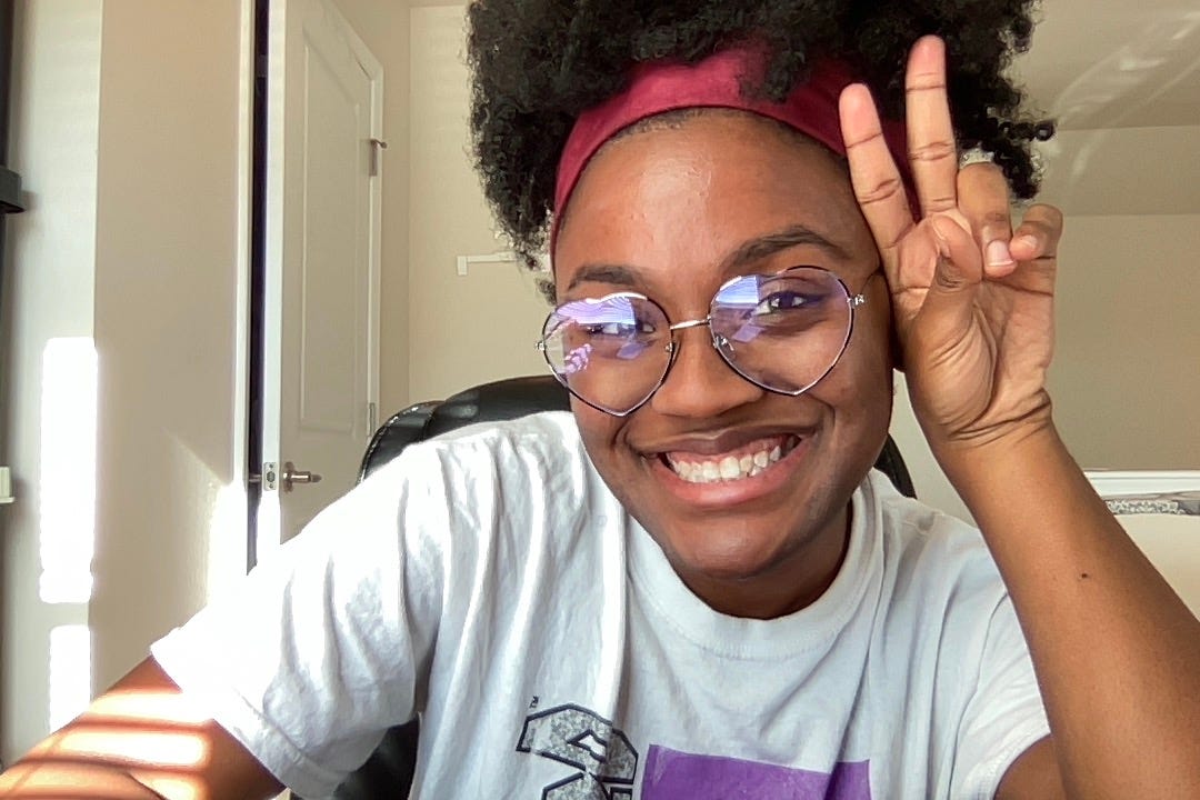 Photo of the author smiling and throwing up a peace sign.