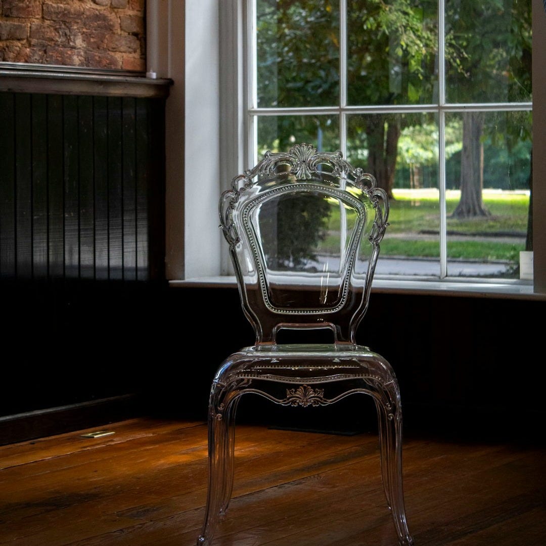 a clear chair sitting in front of a window