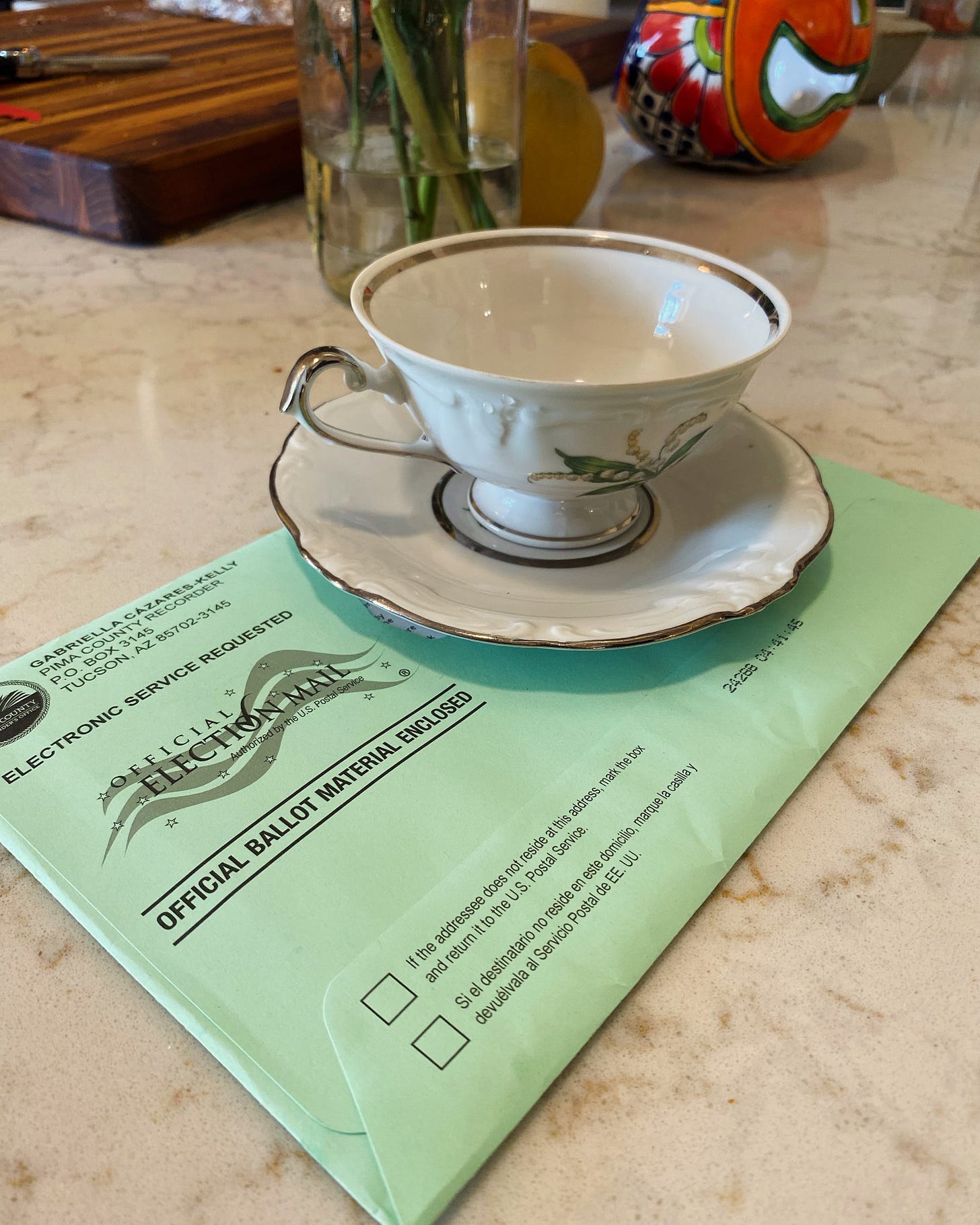 A teacup and saucer sit on a mail-in ballot.