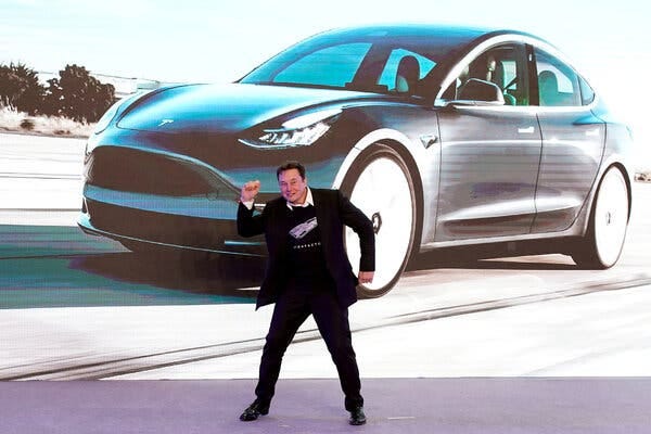 Elon Musk standing in a dance pose during a company event.