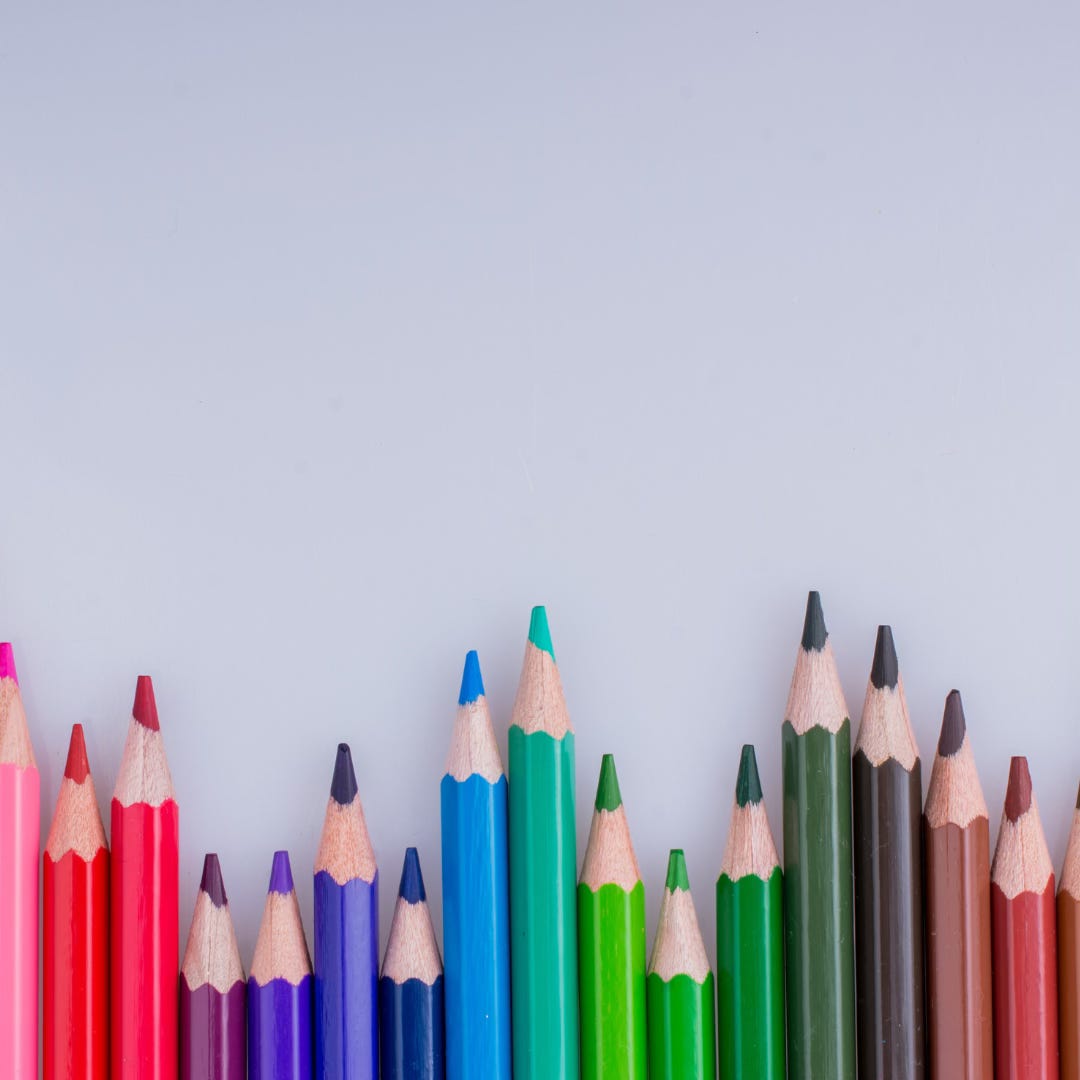 Multicoloured pencils lined up at the bottom of the photo.