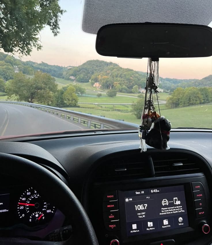 This may contain: the dashboard of a car with an electronic device hanging from it's center console