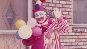 serial killer john wayne gacy as a clown holding balloons