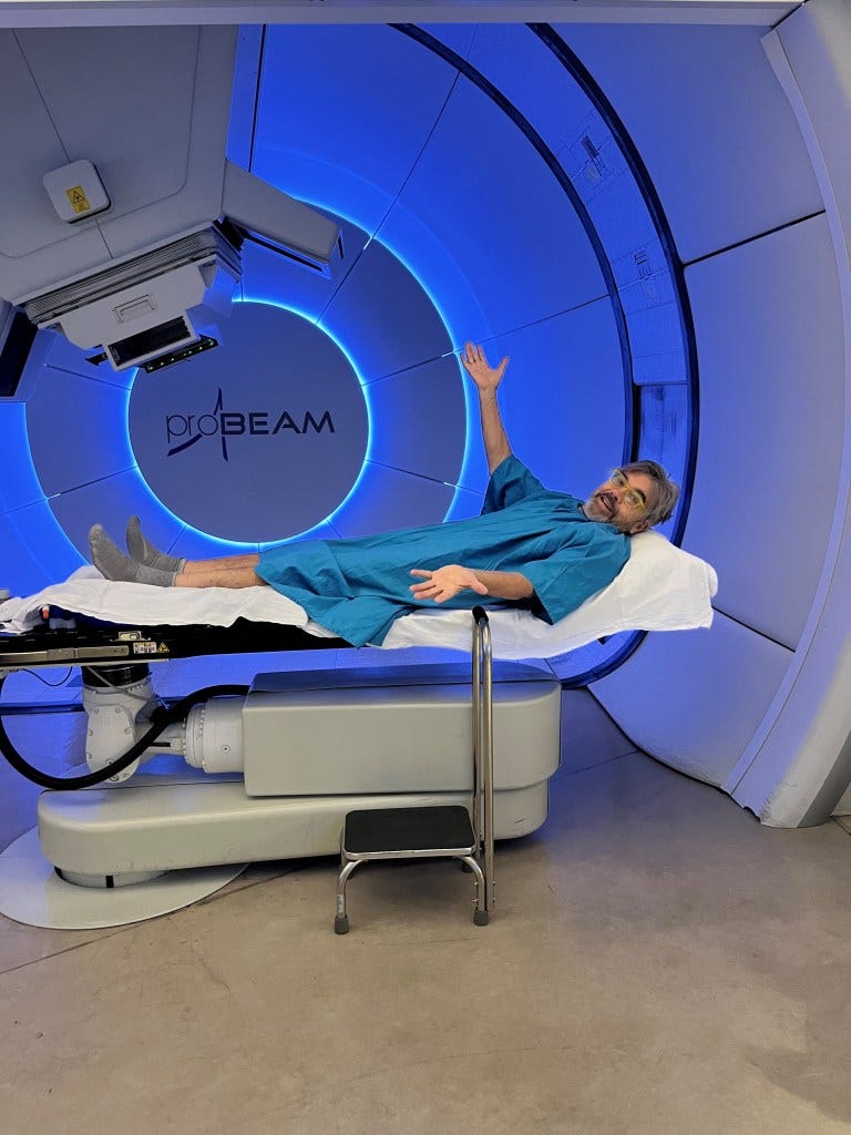 Man lying on a treatment table in a proton therapy room.