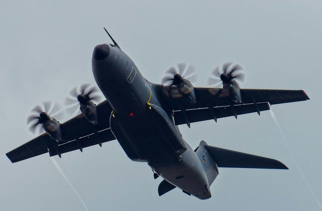 a large air plane flying through a cloudy sky a large air plane flying through a cloudy sky