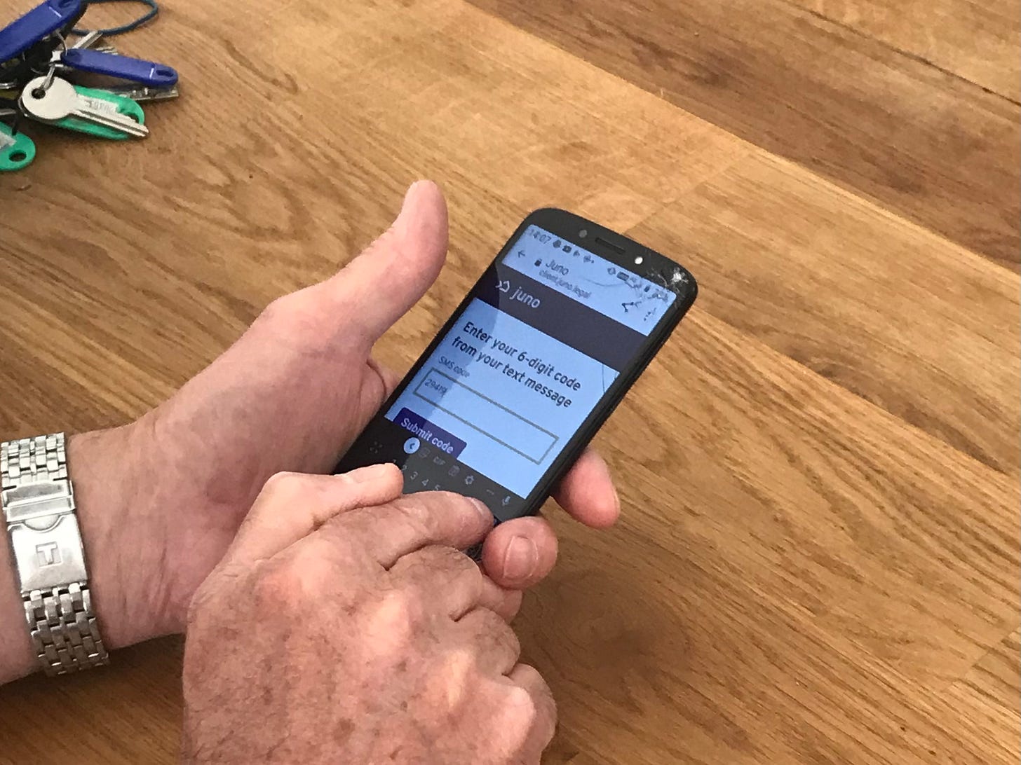 Our neighbour entering a security code on his phone, in our kitchen