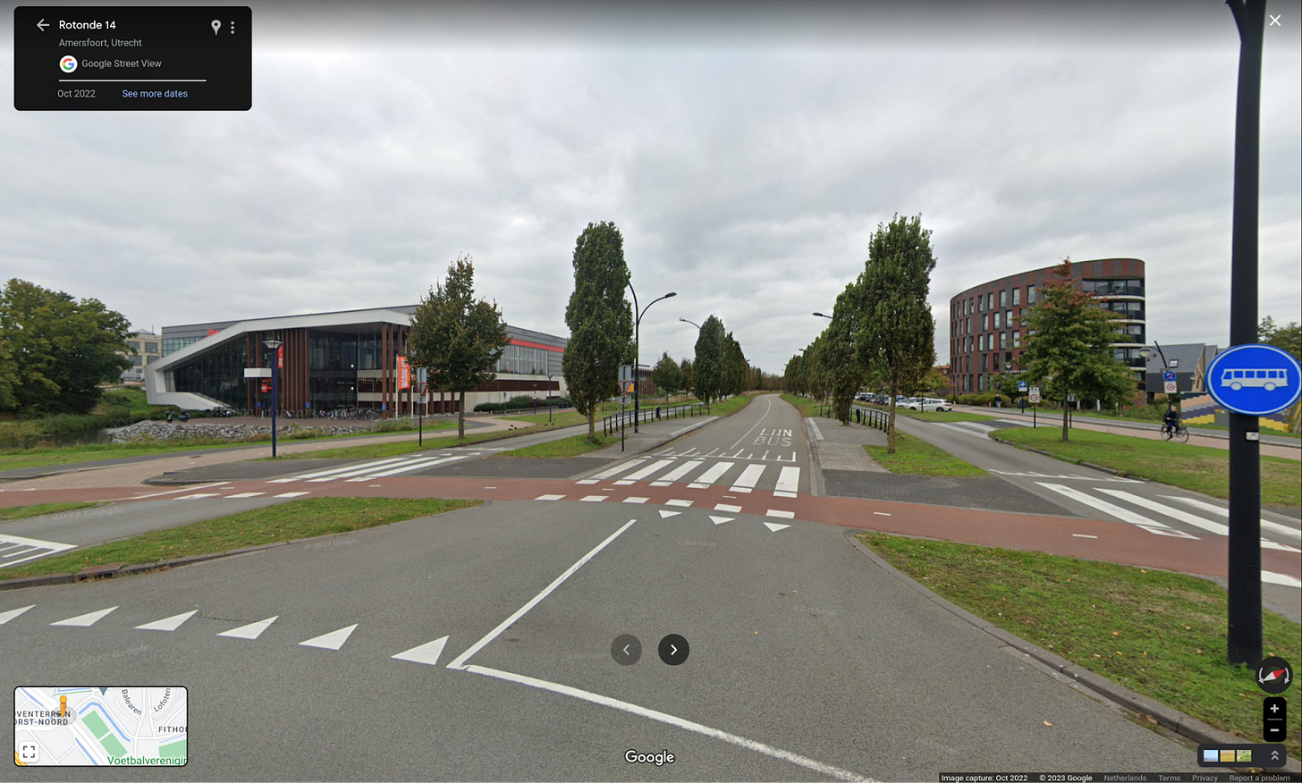 A busway in the middle of a two lane arterial road, with grassey bouleavards separating the roadway from the bus lanes.