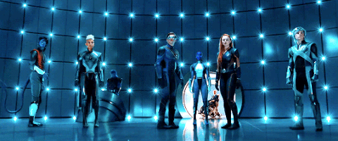 Gif degli X-Men, una squadra di sei supereroi, vestiti con tute attillate futuristiche in tonalità di grigio e blu, si trovano in una stanza circolare futuristica illuminata da una luce blu. Da sinistra a destra, i personaggi sono: un uomo dalla pelle blu con una tuta arancione e nera; una donna dai capelli corti e bianchi; un uomo con occhiali da sole scuri a visiera; un uomo dalla pelle blu (che in realtà è la mutaforma Mystica); una donna dai capelli rossi; e un uomo dai capelli bianchi. Sembrano in posa e pronti all'azione