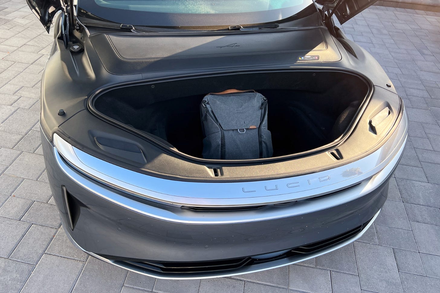 View of a 2023 Lucid Air's front trunk, or frunk, holding a backpack.