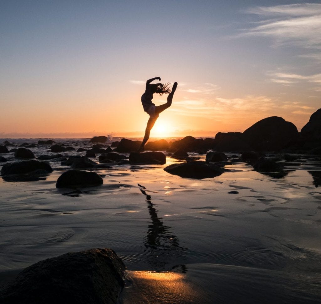 silhouette photography of woman standing on rock silhouette photography of woman standing on rock