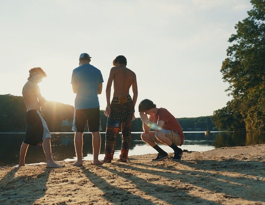 a group of people standing on top of a sandy beach