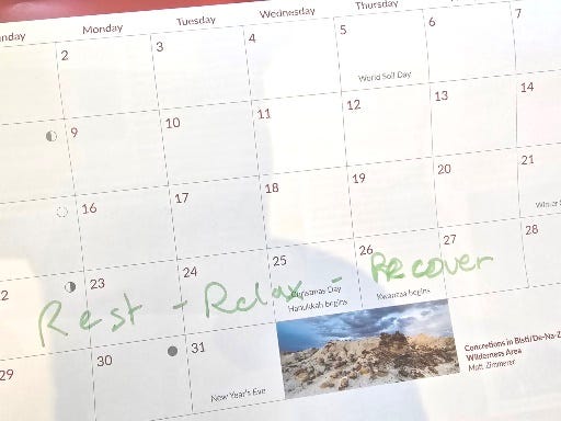 A calendar for the month of December has a note on the week starting December 22. It says Rest - Relax - Recover