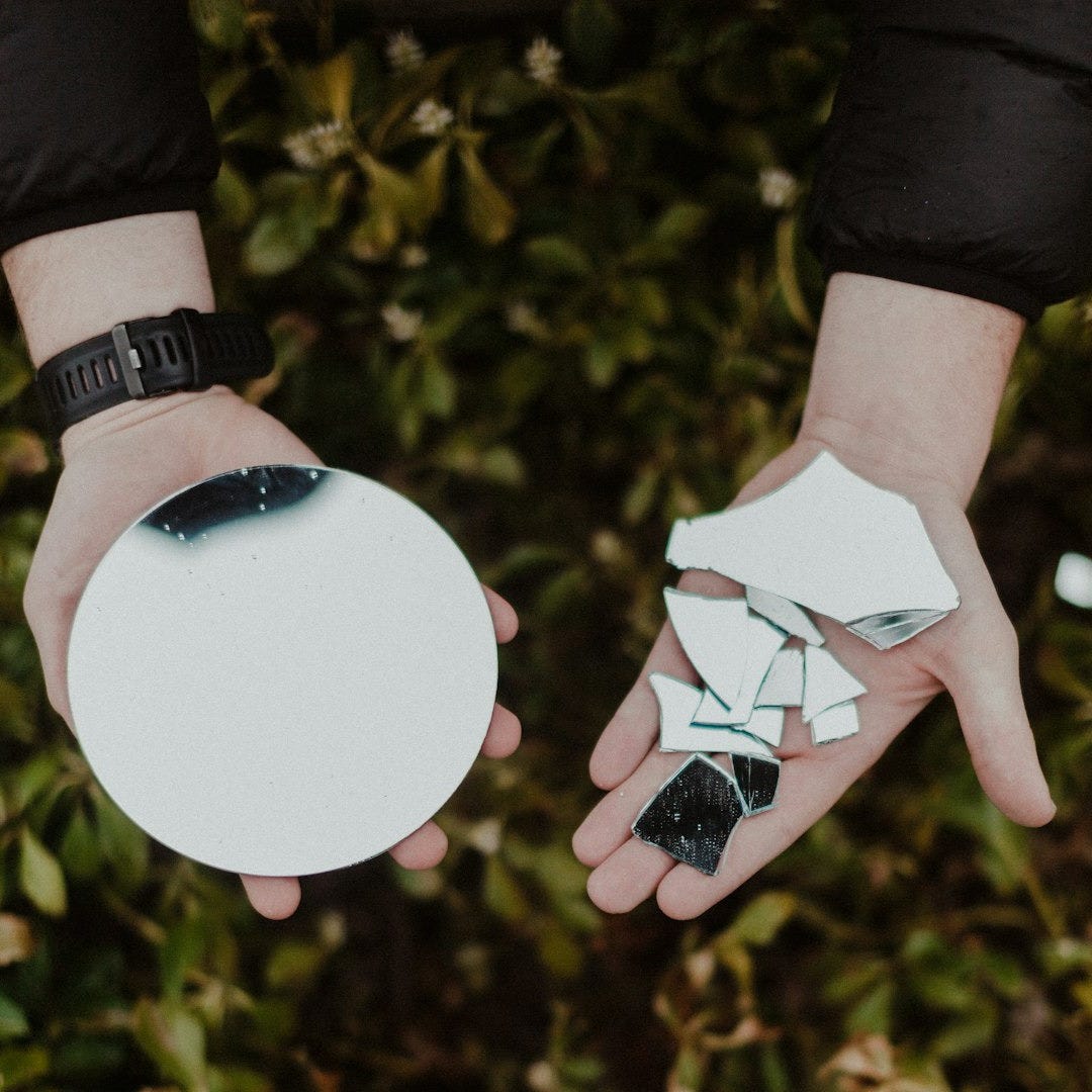 person holding round mirror