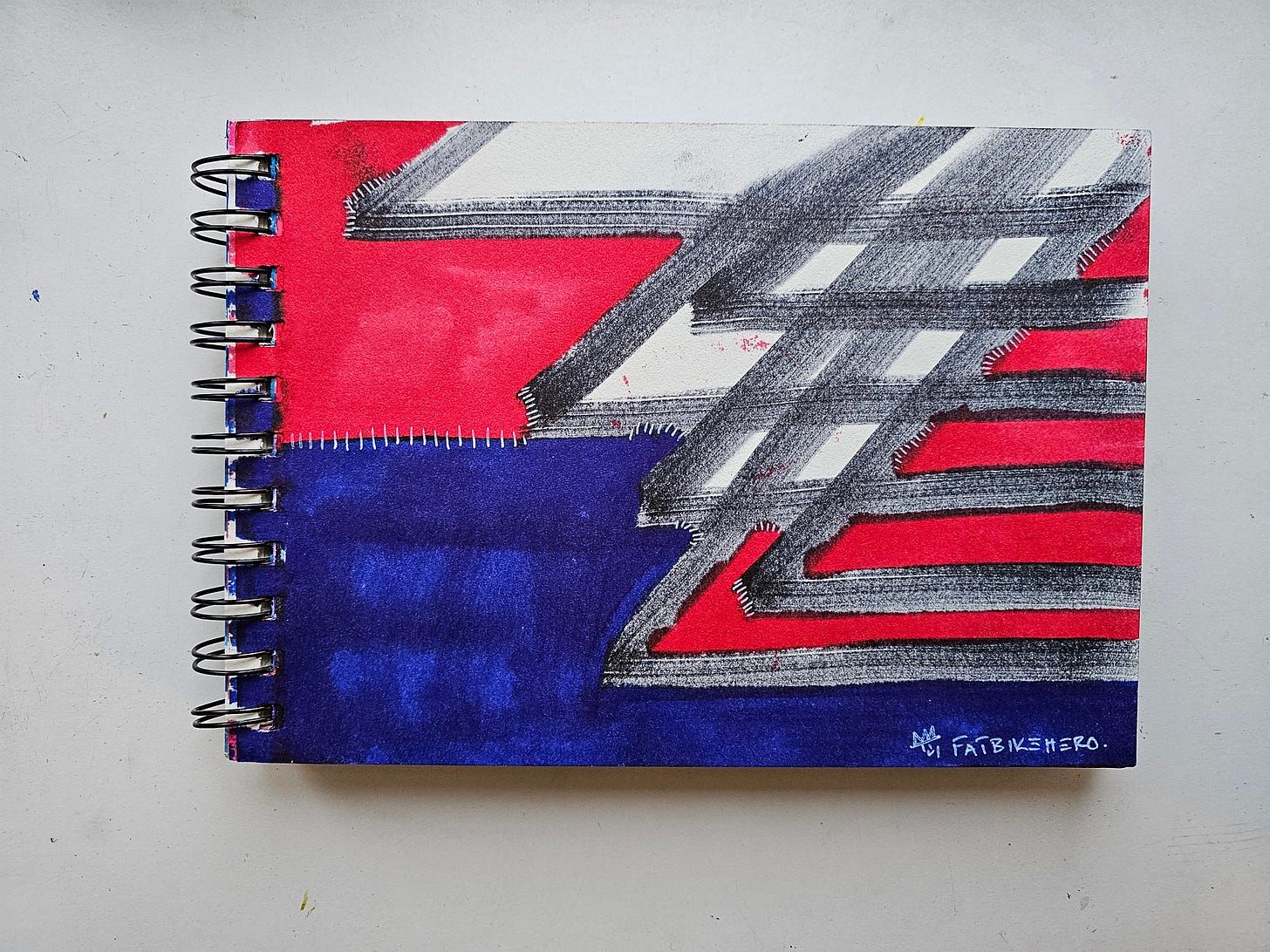 Alt Text: Vertical sketchbook page by Fatbikehero featuring a red and blue painted design. Handwritten text reads "Title: Anti A.I Flag. Note to self: Those who are skeptical of A.I now have a flag that symbolizes the resistance." Dated 20.01.26.