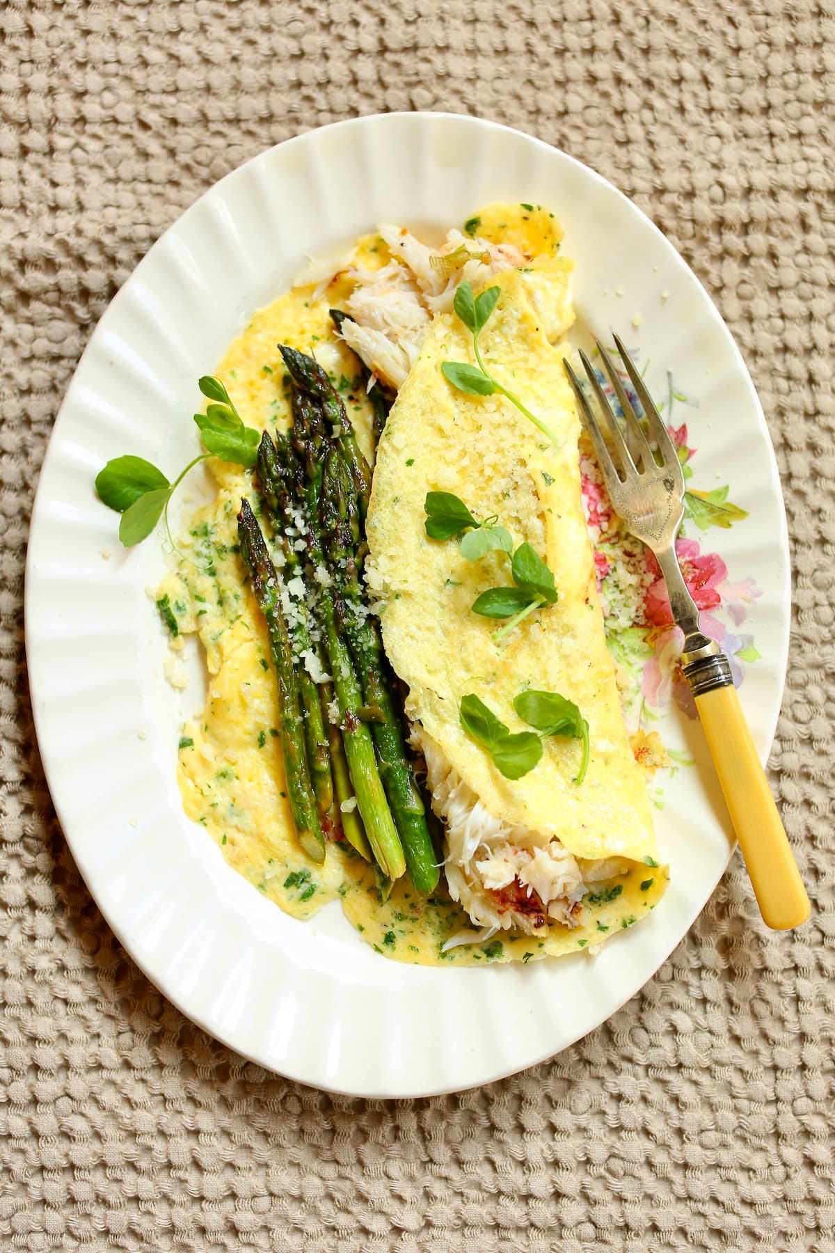 a photo of an omelette om a tan tablecloth.