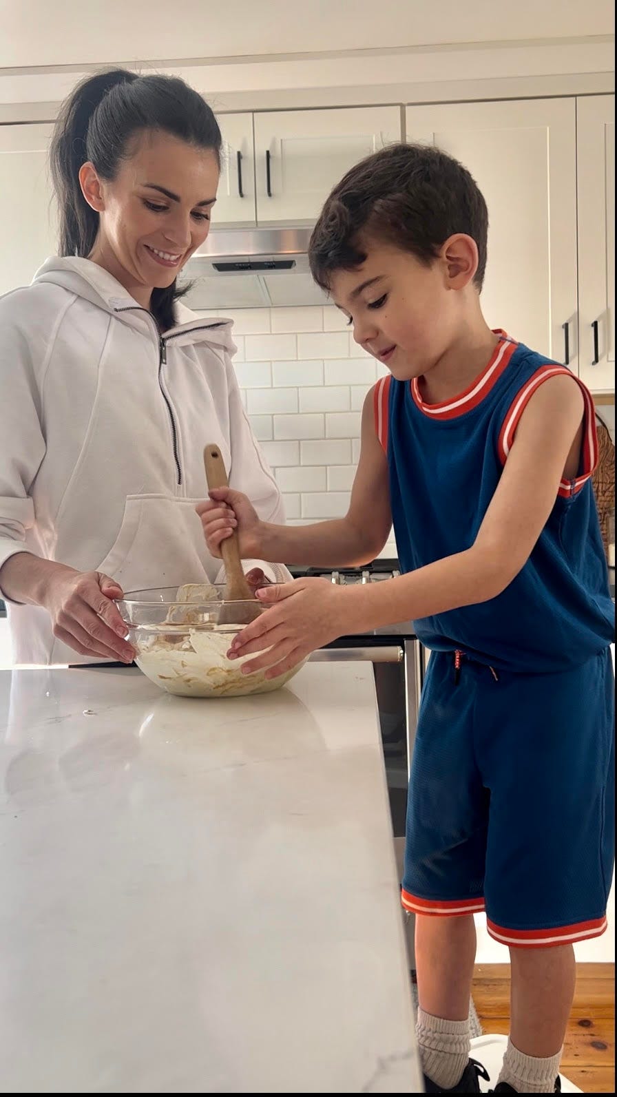 Alina and her son in the kitchen prepping food in a glass bowl