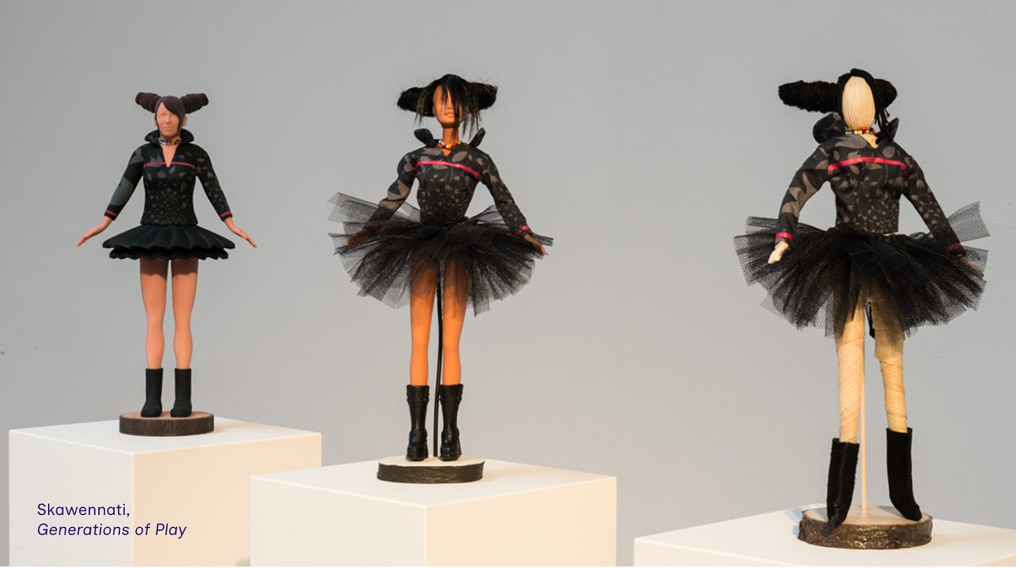 image of three dolls in Skawennati's black and pink punkish black tutu, one which is corn husk, one which is barbie, the other which is a 3D printed digital avatar from Second Life image of three dolls in Skawennati's black and pink punkish black tutu, one which is corn husk, one which is barbie, the other which is a 3D printed digital avatar from Second Life