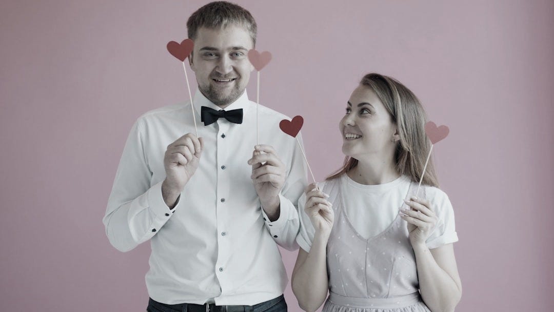 Couple holding red hearts on sticks