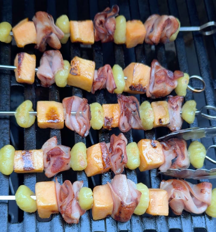 Mortadella, cantaloupe, and gnocchi skewers grilling on a BBQ grill before and after charring