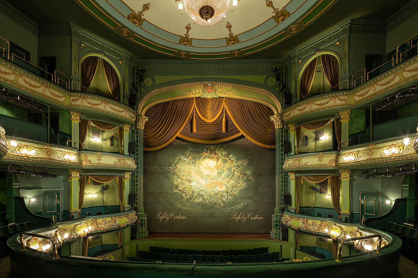 The interior of the Theatre Royal Nottingham auditorium with balconies, dark green paint, and gold detailing The interior of the Theatre Royal Nottingham auditorium with balconies, dark green paint, and gold detailing