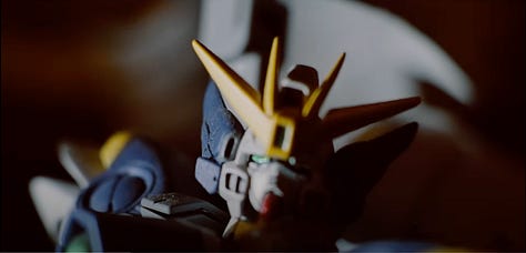 A collection of screenshots from the Somewhere I Belong music video featuring several small plastic models from different Gundam series.