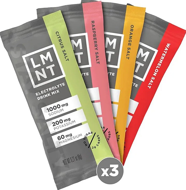 A box of Mezcla protein bars, LMNT electrolyte packets, a bag of Skinny Dipped chocolate almonds, Nespresso pods.