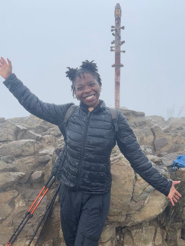 From right to left: A photo of a hiking trail overlooking dark green lush tree. A photo of a black woman smiling dressed in a black zip up jacket with her hands in the air celebrating reaching the top of a peak