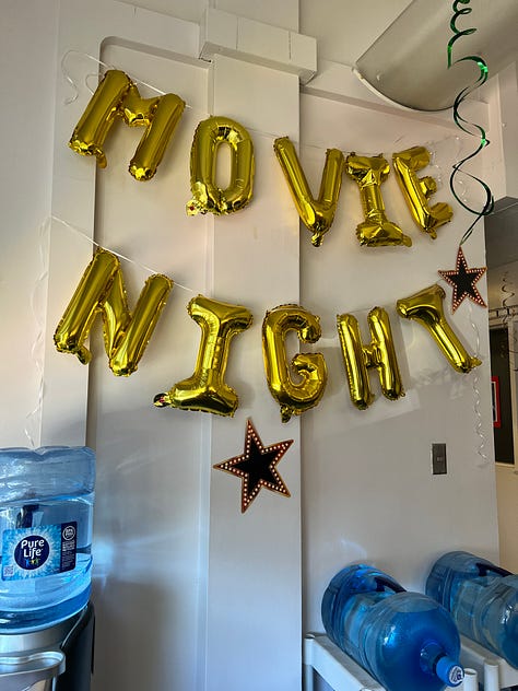 Image 1: Retirement door decoration; Image 2: Movie Night balloons hung on a wall; Image 3: A podium decorated like the Academy Awards; Image 4: A table of retirement decorations and pictures; Image 5: A tree with stars containing funny sayings; Image 6: A giant fake boom box and retirement decorations; Image 7: A tiny fake Oscar statuette; Image 8: An office door with retirement decorations; Image 9: A table with a tiny fake Oscar statuette and a balloon