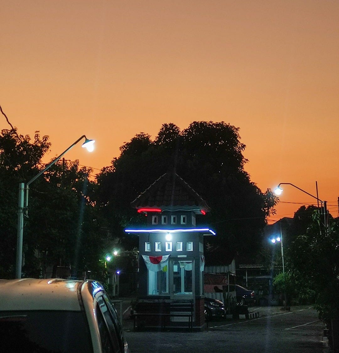 a small building with a lit up sign on top of it a small building with a lit up sign on top of it