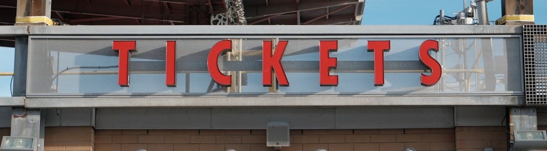 Red letters spell tickets above a building entrance.
