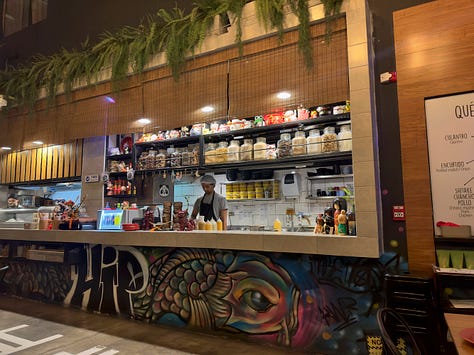 Sutorīto Māketto is a small space decorated with plants, neon signs, and graffiti.